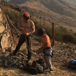 Aventura padre e hijo trabajando en la ladera de una montaña.
