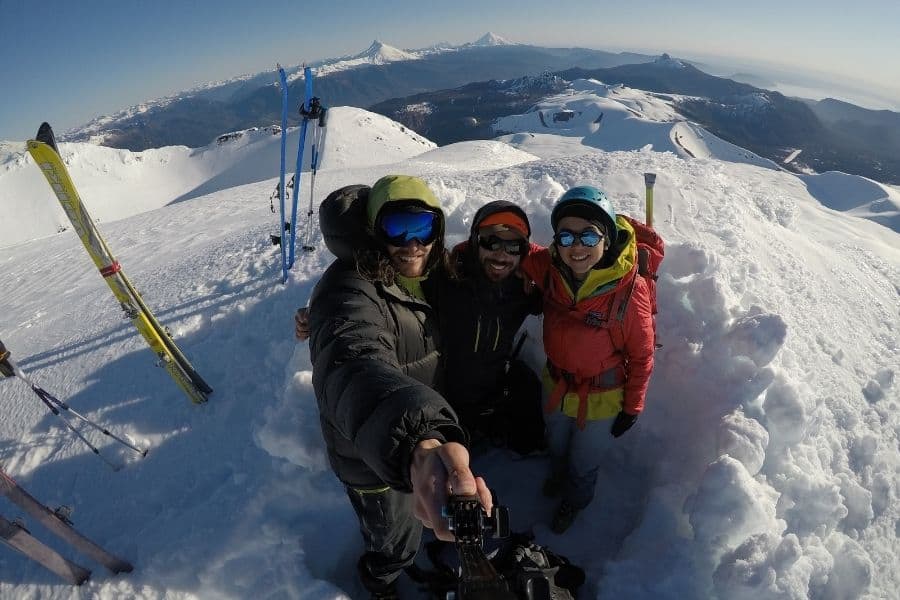 Tres personas haciéndose un selfie en lo alto de una montaña nevada en Antillanca.