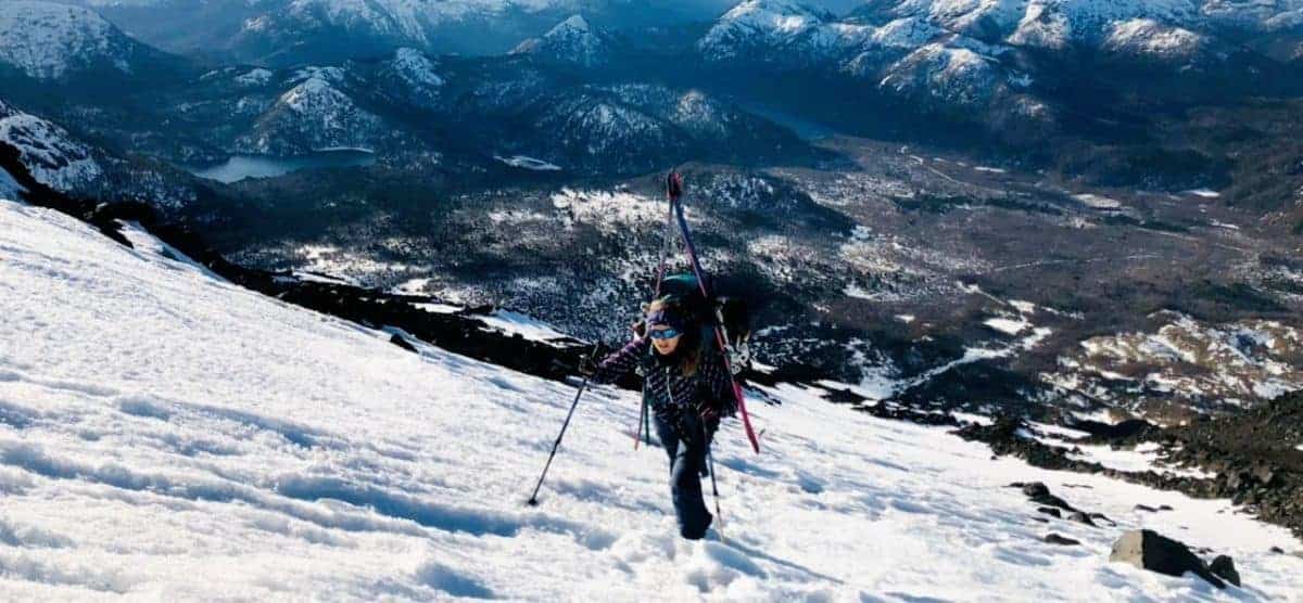 Una persona caminando por el Volcán Lanín cubierto de nieve, experimentando la belleza invernal de la montaña.