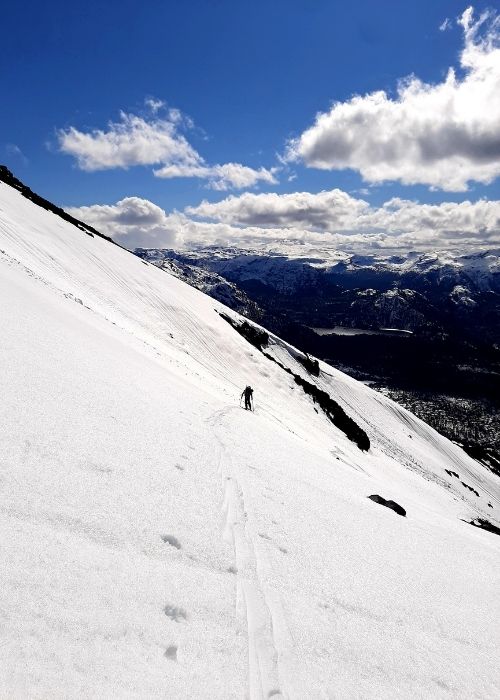 Una persona está esquiando por una montaña invernal.