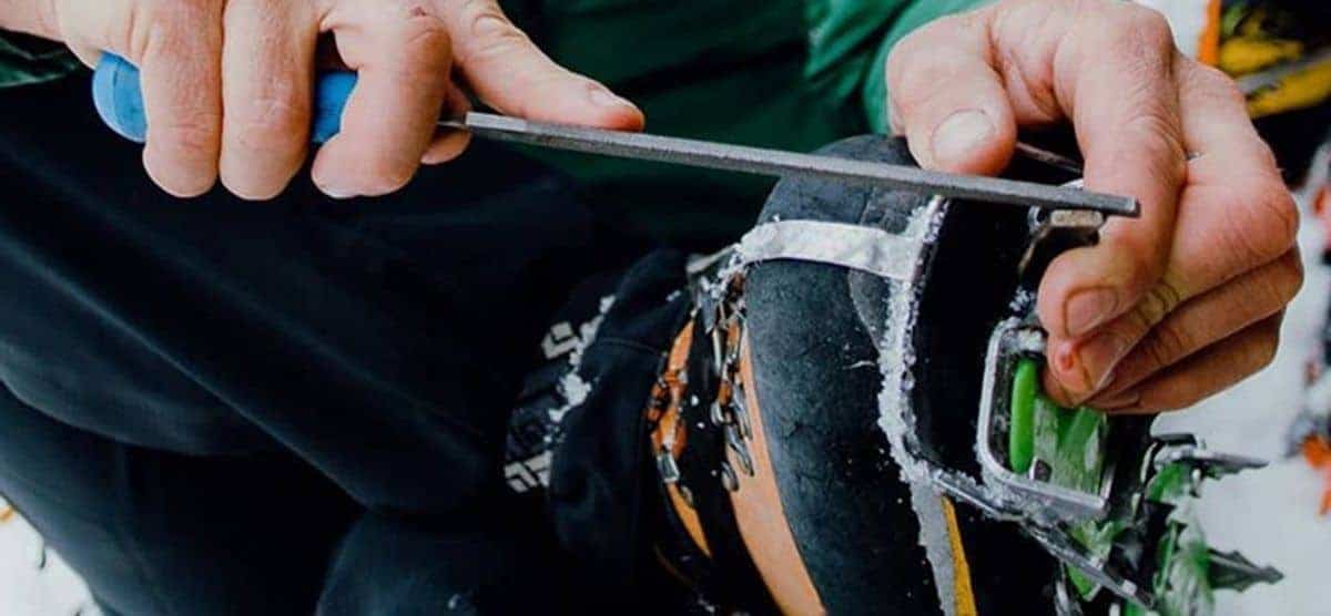 Una persona está utilizando una herramienta de mantenimiento para reparar un par de esquís.