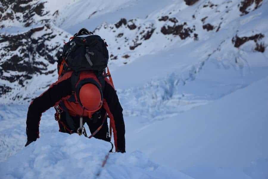 Una persona subiendo una montaña cubierta de nieve en los Andes.
