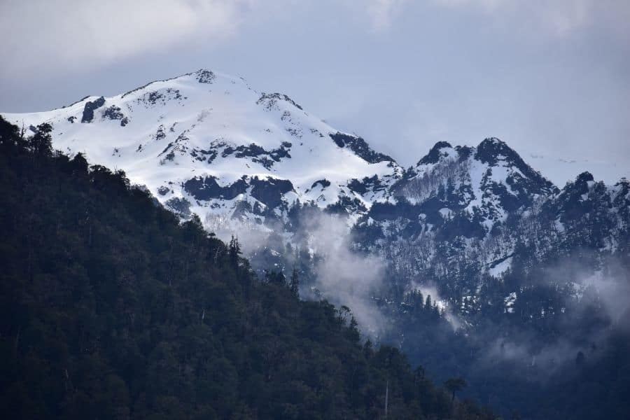 Una hermosa montaña cubierta de nieve, que muestra la majestuosa presencia del Volcán Yates, con árboles al fondo.