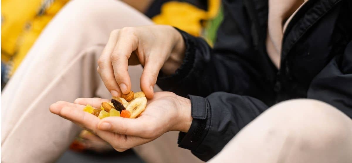 Una mujer sostiene en sus manos un puñado de nueces, una comida y un alimento.