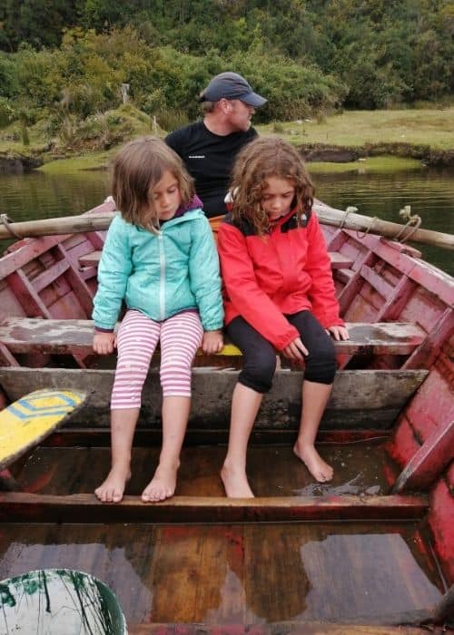 Una familia sentada en la parte trasera de un barco de aventuras de madera.
