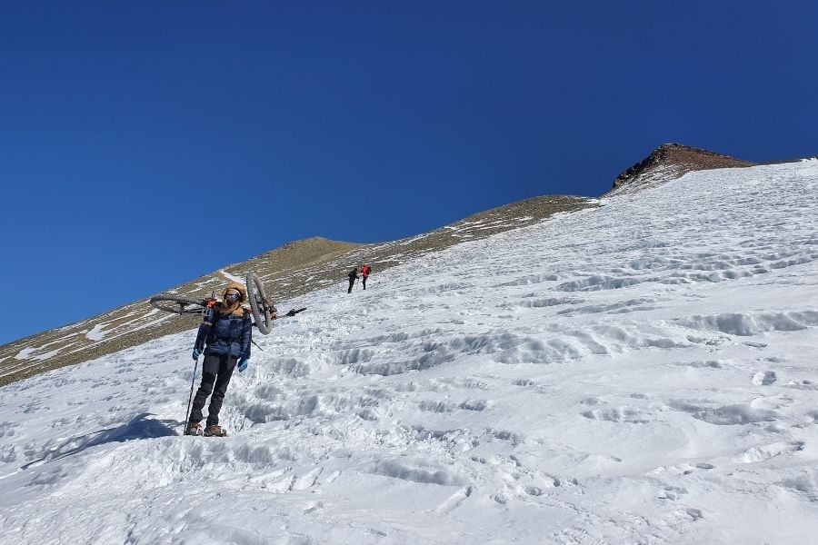 Un grupo de personas desafía un terreno helado mientras suben una montaña cubierta de nieve.