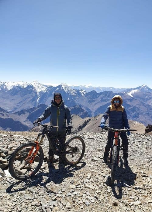 Dos personas en la cima de una montaña con bicicletas de montaña.