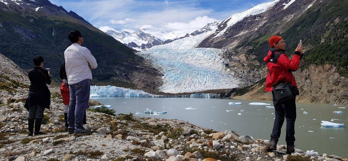 Un grupo de personas mirando un glaciar en la Patagonia.