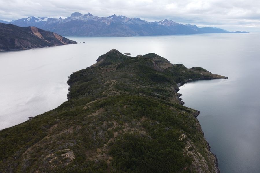 Una vista aérea del fascinante paisaje patagónico, que muestra las majestuosas montañas de Tierra del Fuego y las serenas aguas de Caleta María.