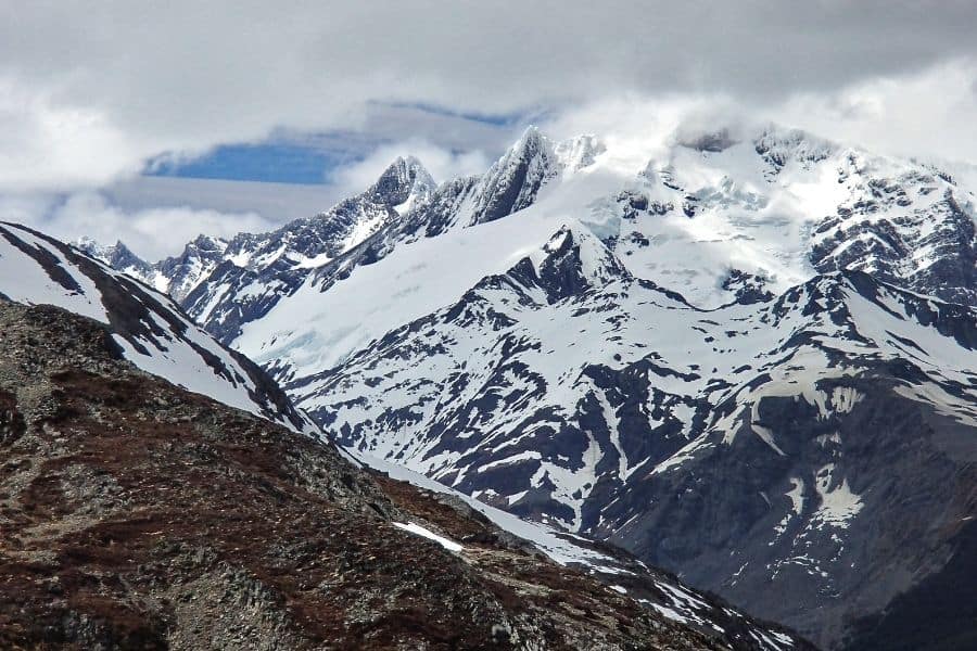 Una cadena montañosa con montañas nevadas al fondo, perfecta para explorar la Patagonia.