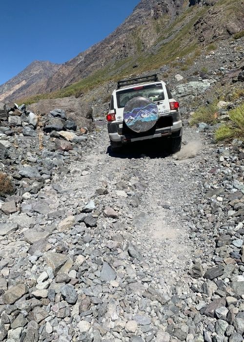 Un jeep terrestre conduciendo por un camino de montaña rocoso en Cajón Las Leñas.