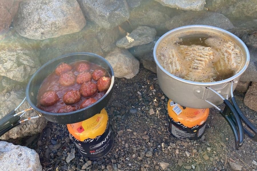Dos ollas de comida sobre una roca, una al lado de la otra, en la región Overland cerca del Cajón Las Leñas.