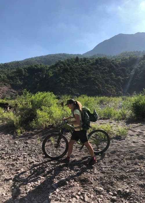 Una mujer descabezada en una bicicleta de montaña recorriendo un sendero de tierra.