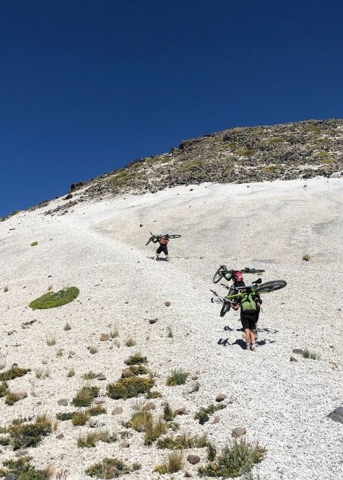 Dos personas conquistando el monte descabezado con sus bicicletas.