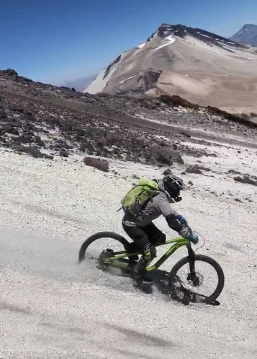 Una persona andando en bicicleta por una montaña nevada.