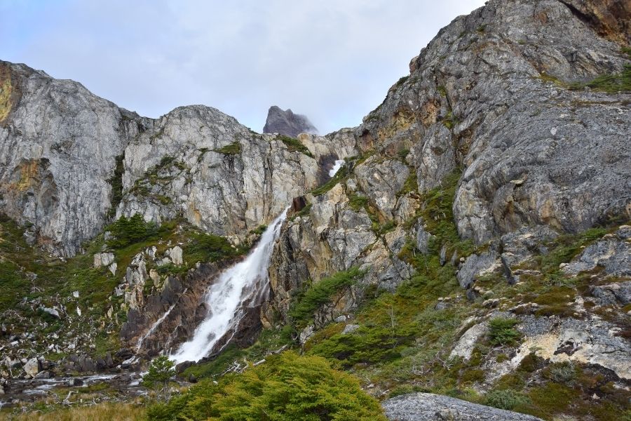 Una impresionante cascada en la Patagonia, enclavada en medio del paisaje de montañas rocosas.