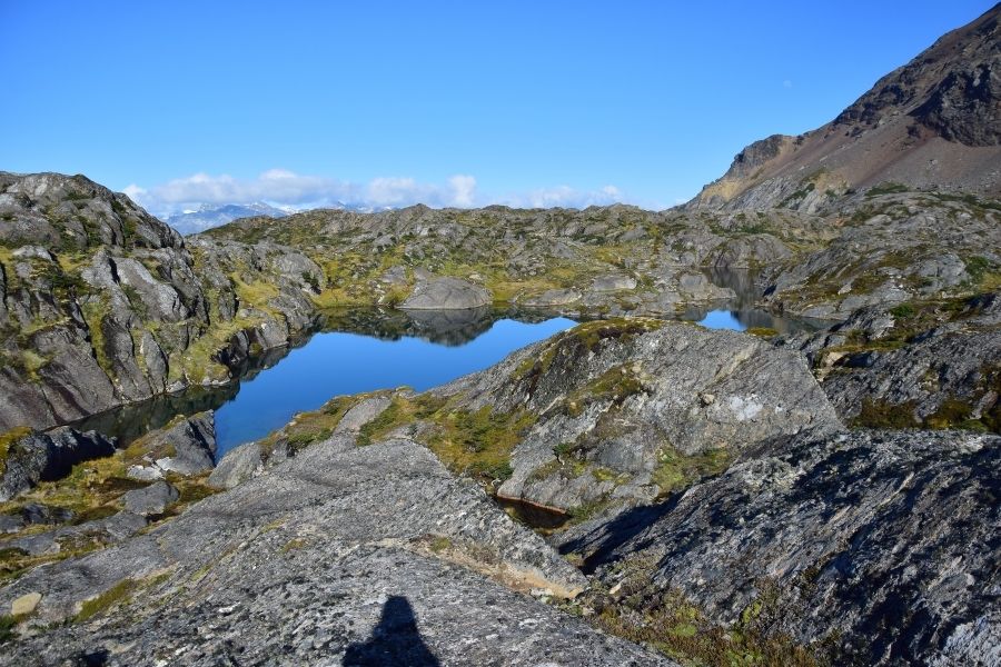 Una montaña rocosa con un lago en el medio, ubicada en la Patagonia.