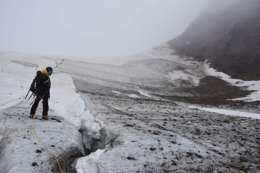 Un hombre está parado sobre un glaciar en la Patagonia.