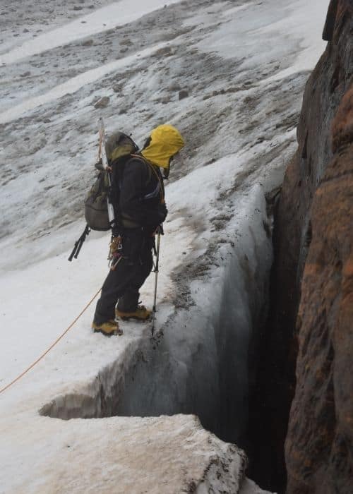 Un hombre intenta el primer ascenso por una pendiente pronunciada en La Muela, Patagonia, utilizando una cuerda.