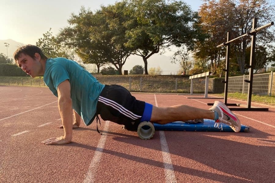 Un hombre realizando flexiones en una pista mientras combina elementos del trail running para mejorar el rendimiento.