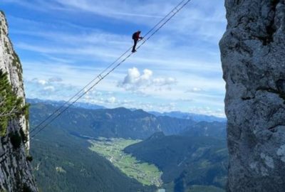 Una persona practica vía ferrata, un emocionante deporte que combina elementos de escalada y colgarse de una cuerda en un acantilado.